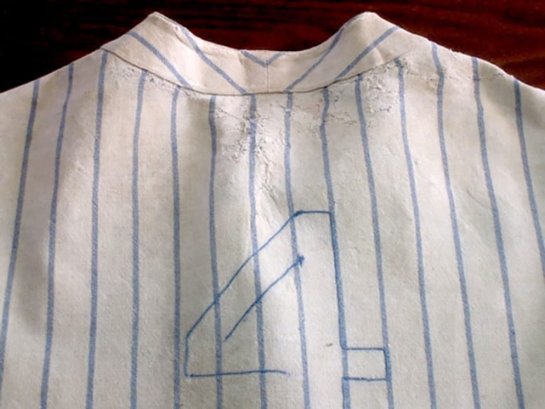 Back view of Lou Gehrig's NY Yankees #4 jersey mounted on a dress form after conservation, showing the restored number and overall stabilized condition.