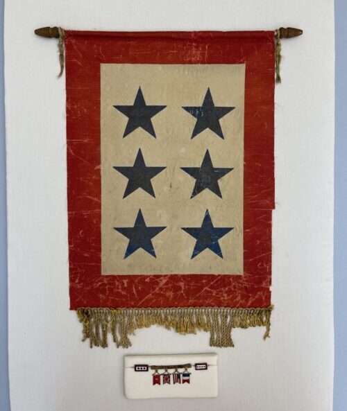 Service banner with six blue stars on a cream field and red border, shown stabilized with fringe aligned and surface flattened.
