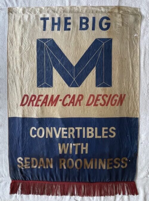 Printed fabric advertising banner reading “The Big M Dream-Car Design,” shown cleaned and flattened with red fringe intact.