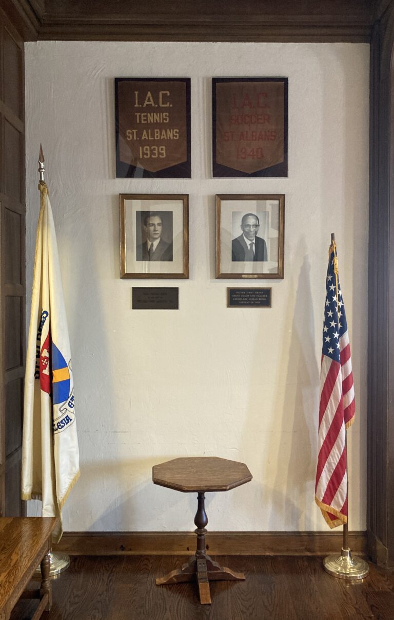 A small display alcove with two historic I.A.C. banners reading “Tennis St. Albans 1939” and “Soccer St. Albans 1940,” mounted above two framed portrait photographs.