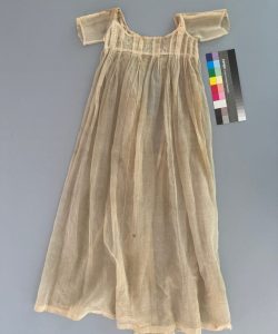 Cream colored christening gown before treatment, showing discoloration.
