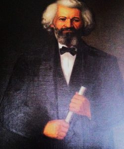 Frederick Douglass portrait of distinguished, bearded man in black suit with bow tie, holding a white scroll.