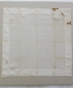 Frederick Douglass restored white handkerchief showing wear along folds and brown stains in upper right corner..