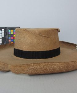 Frederick Douglass damaged tan straw hat with black band.