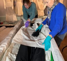 Julia and her colleague unwrapping and examining a black gown from Princess Grace Kelly’s collection for exhibition.