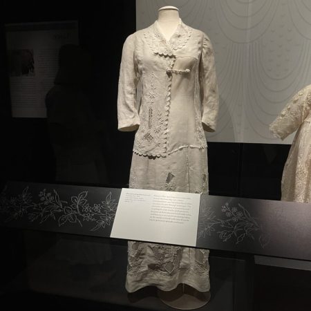 Display of cream-colored linen long skirt and long-sleeved jacket on a dress form.