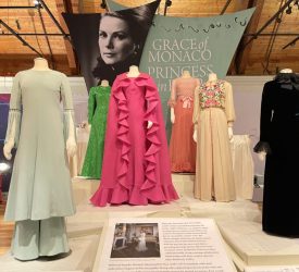 Princess Grace Kelly’s gowns displayed beneath the exhibition banner at Marjorie Merriweather Post’s Hillwood Estate.